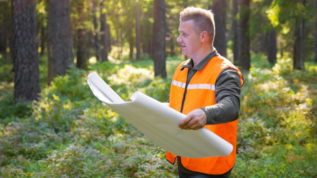 Man holding a blueprint of the land.