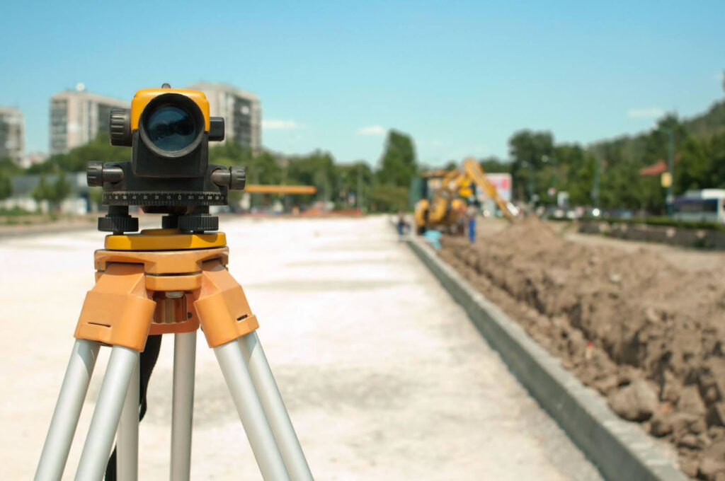 Surveying equipment on tripod at construction site used for drainage planning and land development